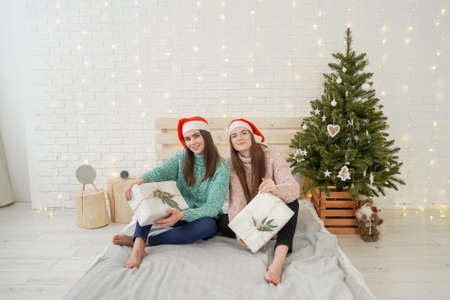 Women Exchanging Christmas Gifts near christmas treeの写真素材