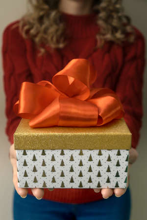 Woman hold gift box with red bow.の写真素材