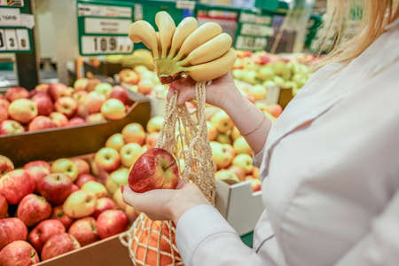 Female hands with cotton bag in supermarket.の写真素材