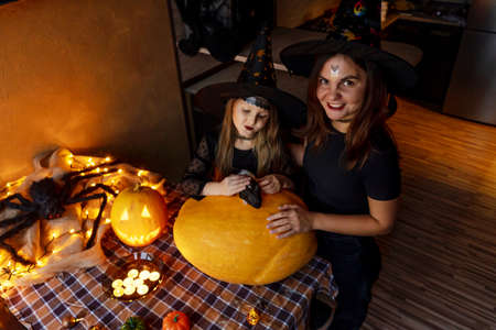 Mother daughter carving pumpkin. Preparing for halloween.の写真素材