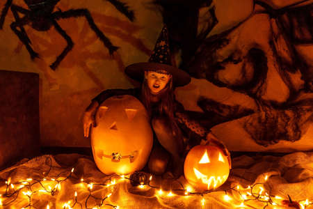 Girl in witch costume celebrate Halloween. Darkness.の写真素材