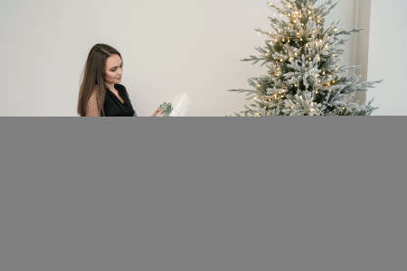Women open Christmas Gifts near christmas treeの写真素材