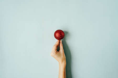 Christmas ball in hand on blue background.の写真素材