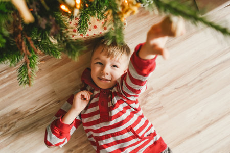 Happy little boy and Christmas tree, top view.の写真素材