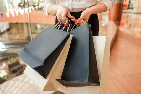 Woman with shopping bags in mall. Without head.の写真素材