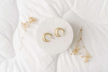 Golden modern bijouterie earrings on white background.の写真素材