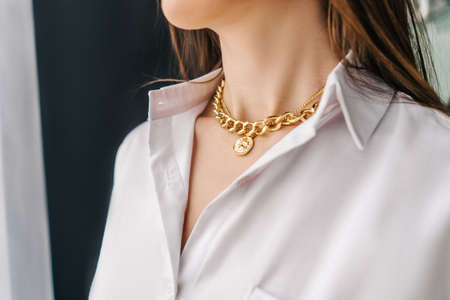 Silver bijouterie chain on woman neck. Close-up.の写真素材