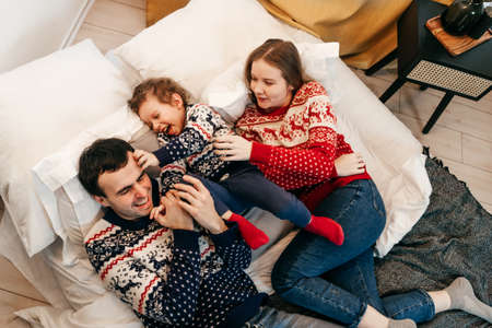 Happy family have fun on bed. Home.の写真素材