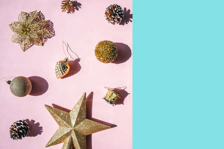 Trendy pattern from golden baubles on pink background. Christmas concept. Copy space on blue.の写真素材