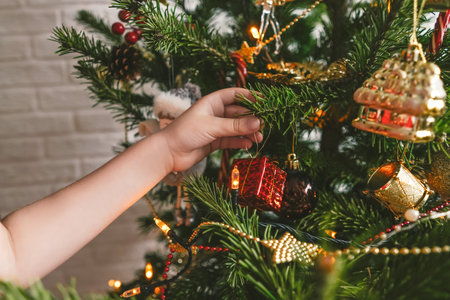 Beautiful decorated Christmas tree and childs hand..の写真素材