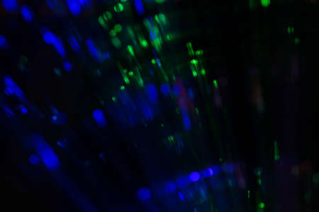 Blurred green and blue light bokeh in black background. Copy space.