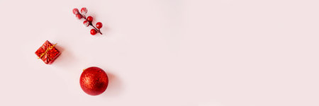 Red Christmas baubles decoration on pink background. Flat lay, copy space. Holiday concept. Minimalism. Web banner.の写真素材