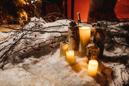 Candles in the snow, branches as decoration. Night magic atmosphere, natural decorations for Christmas.の写真素材