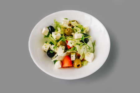 Greek salad on gray solid background. Fresh microgreen on salad. Front view.の写真素材