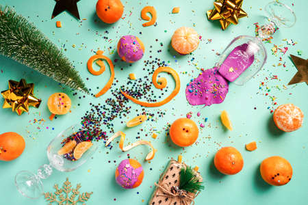 Christmas bright composition with tangerines, christmas tree, gift box and wine glasses with purple paint. Flat lay, top viewの写真素材