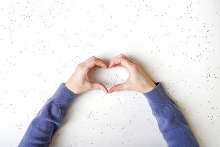 Female hands making sign Heart by fingers.