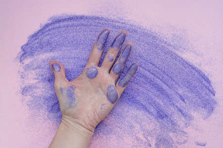 Purple glitter and hand with violet sequins.の写真素材