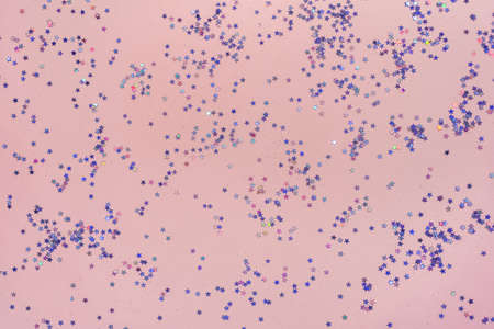 Pink background with small purple holographic sparkles.の写真素材