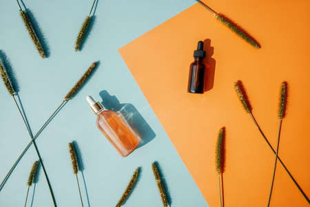 Face serum bottles on blue and orange bacgrounds.の写真素材