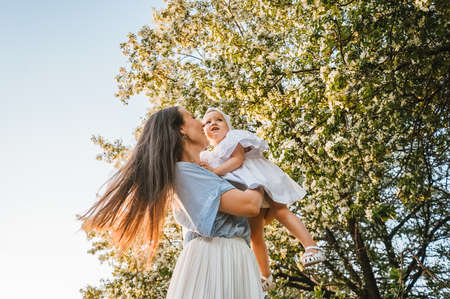 Mother and little daughter near blooming apple tree.の写真素材