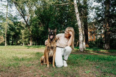 Woman with dog in park on the walk.の写真素材