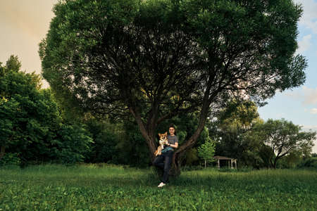 Woman with dreadlocks walk with dog corgi.の写真素材