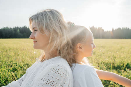 Mother and daughter on sunset in field.の写真素材
