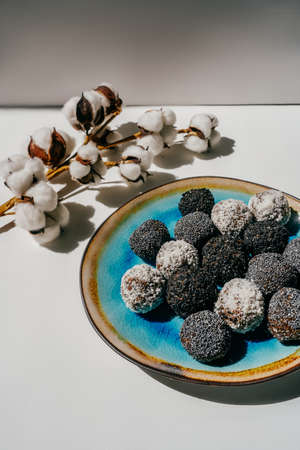 Homemade date candies covered with poppy, sesame and shredded coconut.