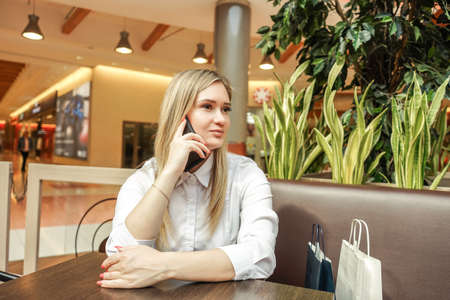 Smiling woman with shopping bags in mall.の写真素材