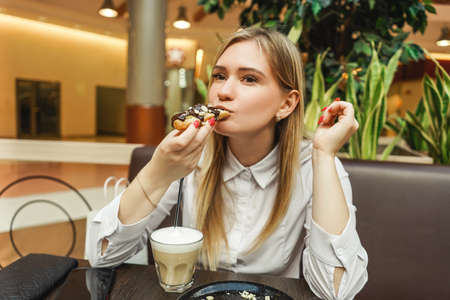 Smiling woman in sunny cafe waiting coffee.の写真素材