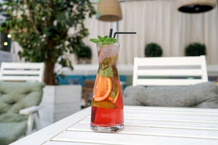 A cold lemonade of fresh tropical fruits. Red cocktail on table in street cafe.の写真素材