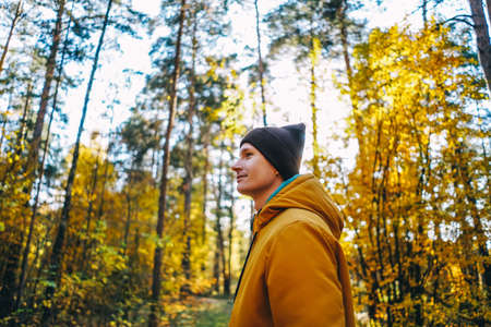 Portrait of Young man in autumn forest. Profile view.の写真素材