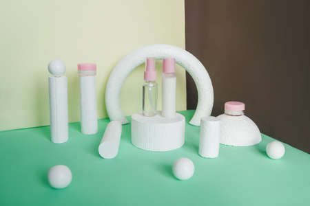 Blank white cosmetic bottles on white podiums. Abstract background yellow, brown and turquoise colors.の写真素材