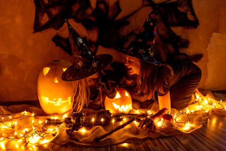 Family fun mother and child daughter having fun and celebrate Halloween in witch costume. Jack-o-lantern.の写真素材