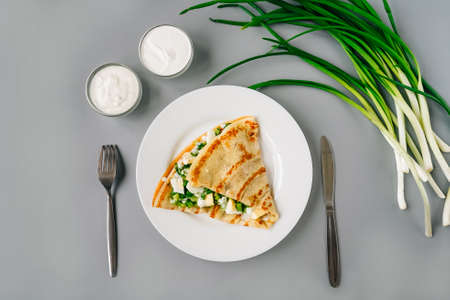 Person eating crepes with filling. Tasty breakfast on gray background.の写真素材