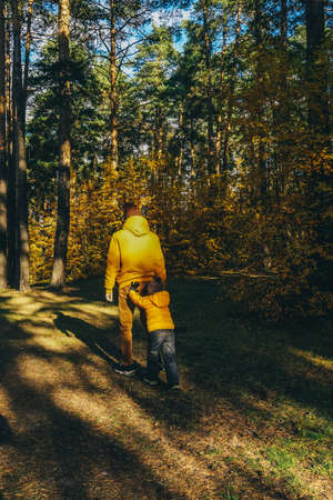 Father and son having fun in autumn forest.の写真素材