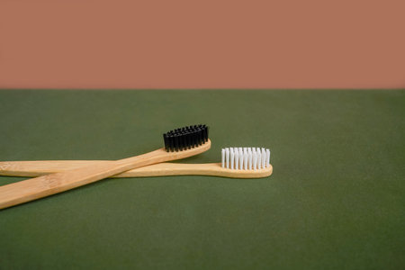 Natural bamboo toothbrush on green and beige background. Front view, copy spaceの写真素材