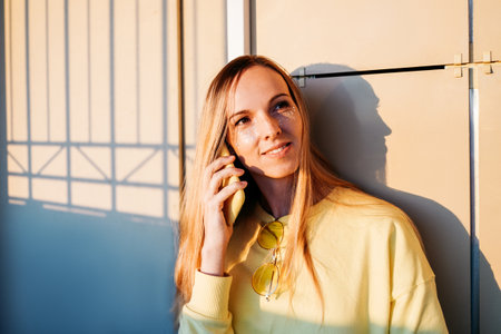 A woman is smiling and speaking at phone.の写真素材