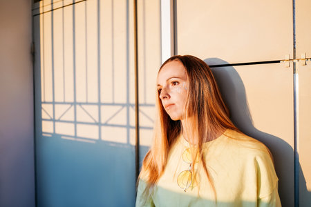 Young thoughtful caucasian woman leaning on the wall.の写真素材