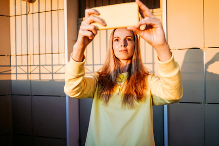A woman is smiling and taking selfie.の写真素材