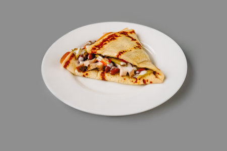 Person eating crepes with filling. Tasty breakfast on gray background.の写真素材