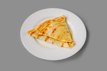 Person eating crepes with filling. Tasty breakfast on gray background.の写真素材