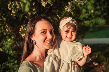 Mother and little daughter near blooming apple tree.の写真素材