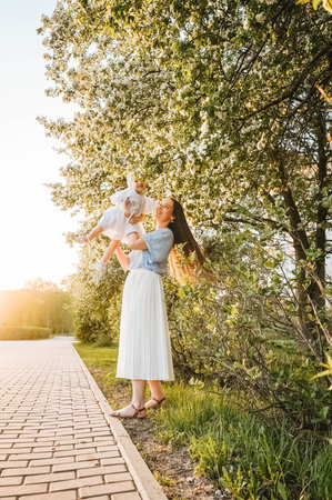 Mother and little daughter near blooming apple tree.の写真素材
