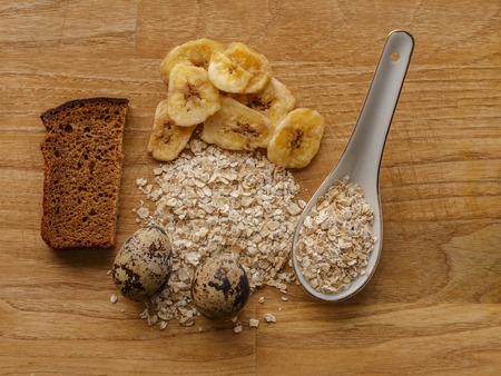 oatmeal and eggs and bread and banana chips wood texture top viewの写真素材