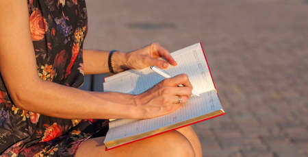 close up woman hand with pen writing on calender for note or make appointment concept.の写真素材
