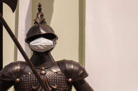 armor of a knight with a medical mask during quarantine at the entrance to a restaurant.