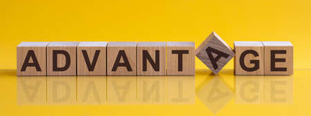 ADVANTAGE - word from wooden blocks with letters, concept, yellow backgroundの写真素材