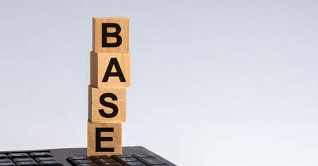 BASE-text on wooden cubes located on the keyboard, gray background.の写真素材