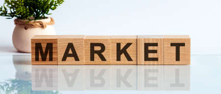 Wooden Blocks with the text: MARKET. The text is written in black letters and is reflected in the mirror surface of the table. New business relaunch startup concept.の写真素材